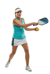 Senior woman playing pickleball with dynamic action. Active retirement concept.