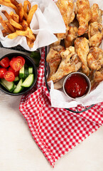 Spicy chicken wings and french fries.