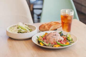 テーブルに並ぶ肉料理とサラダと飲み物の食事風景