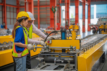 Engineer and technician inspecting materials on factory production line while discussing data on laptop. Great for industry, manufacturing, teamwork, and quality control concepts.
