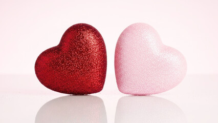 Two sparkling hearts, one red and one pink, side by side
