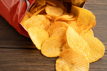 Potato chips, delicious BBQ seasoning spicy for crips, thin slice deep fried snack fast food in open bag.