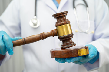 Doctor holding judge gavel, forensic medicine, medical law and crime justice.