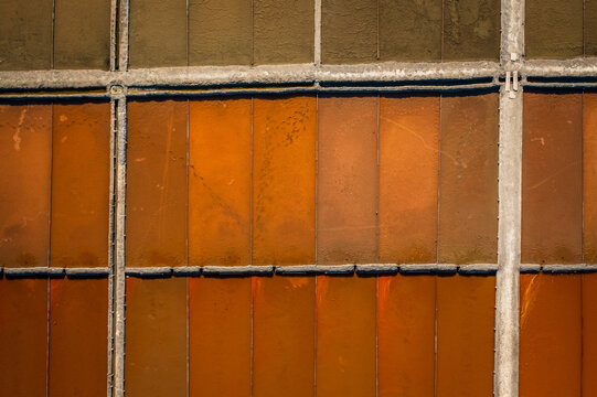 Aerial view of salt ponds reflecting fiery hues of orange and earthy browns under the sun, creating a mosaic of textures and tones, Aveiro, Aveiro, Portugal.