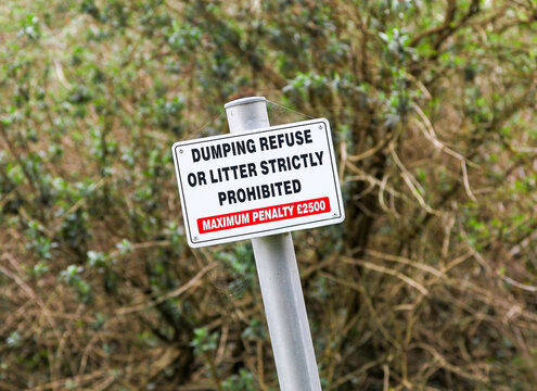 A sign post saying dumping of refuse or litter strictly prohibited, maximum penalty &pound;2500, England, UK