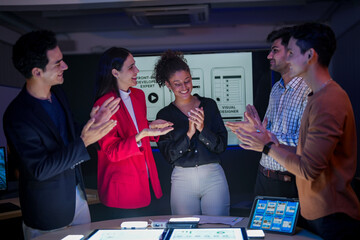 Successful creative team celebrating project achievement in modern office. Happy diverse developers...