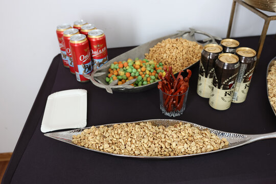 Buffet table with Kozel beer snacks, sausages, nuts and beverages.