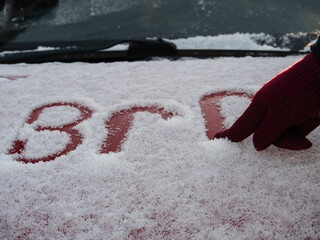 Hand writing on a car covered in snow
