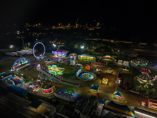 Aerial view of a vibrant carnival illuminated against the night sky, with twinkling lights and thrilling rides creating a mesmerizing scene, Nassau, Bahamas.