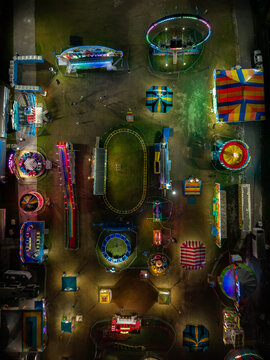 Aerial view of a fairground lit up with vibrant colors and thrilling rides under the night sky, Nassau, Bahamas.