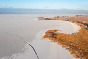 Frozen lake covered in snow, seen from a drone. Winter landscape. Lake Dabie in Poland.
