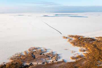 Frozen lake covered in snow, seen from a drone. Winter landscape. Lake Dabie in Poland.
