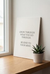 Motivational quote canvas on windowsill with succulent