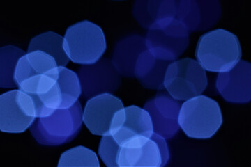 Abstract blue hexagonal bokeh lights on a dark background, ideal for creative and tech concepts.
