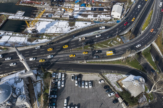 Aerial view of a modern highway weaving through the historic cityscape alongside a mosque with a tall minaret, contrasting the old and new, Istanbul, Istanbul, Turkey.