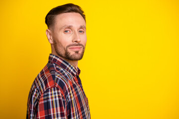 Portrait of a young handsome man in plaid shirt posing against a bright yellow background for casual fashion lifestyle advertising and shopping campaigns