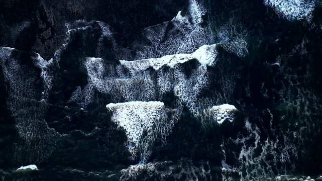 90 degrees aerial view Atlantic ocean waves crashing on the coast. Slow motion 4K