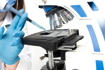 A professional conducting scientific experimentation with tools and equipment in a sterile environment using a microscope