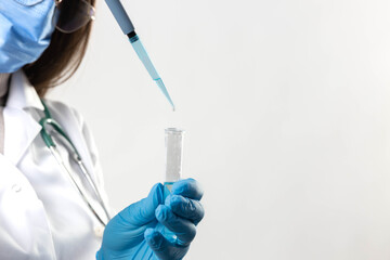 A lab technician carefully adds liquid to a test tube using a pipette for scientific analysis.