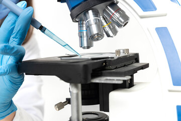 A scientist carefully examines a sample slide under a microscope for analysis and research.