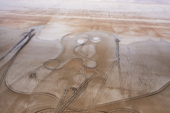 Aerial view of tyre track patterns etched into the expansive, sun-baked earth, creating a surreal landscape of curves and lines, Lake Tuz, saray/van, Turkey.