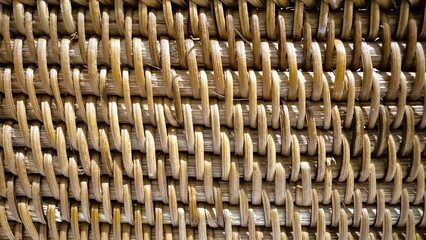 Closeup woven rattan texture showing warm interlaced fibers and natural tones, detailed shot of basket weave ideal for product styling, boho interior backdrops, sustainable craft displays and social