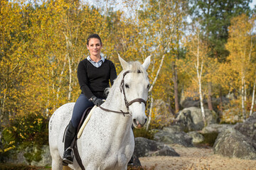 Fototapeta premium View on a woman rider with her horse in forest