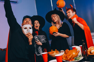 Friends enjoying a Halloween party at a bar making a toast