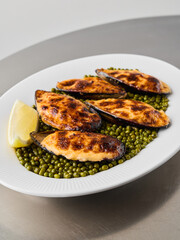 close vertical shot of baked mussels on peas, editorial