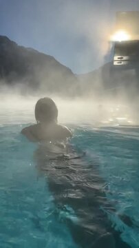 Woman in swimming pool outdoors in winter