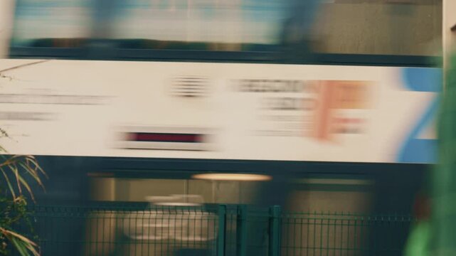 Abstract shot of a high speed train passing behind a metal fence, creating motion blur and geometric line