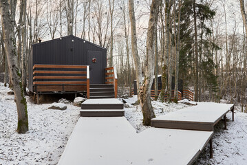 Chic elevated dwelling on stilts with snowy landscape and porch