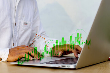 financial analysis and stock crypto trading concept with person typing on laptop and digital graphs overlay