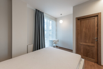 Minimalist Bedroom Interior With Wooden Door and a Bright Window View