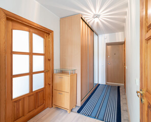 Spacious Minimalist Hallway Interior with Wooden Doors and Storage Furniture