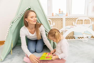 Mother and daughter playing in the tent