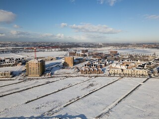 heavy snowfall in the Netherlands covers fields in polder and causes disruption in residential areas with closed roads. Drone footage of winter weather snow scene beautiful landscape  