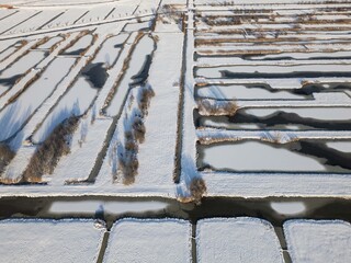sun shines on heavy snowfall in the Netherlands covers farmland fields in polder. Drone footage of rural winter weather snow scene beautiful landscape  