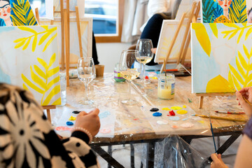 Women enjoying a sip and paint art workshop