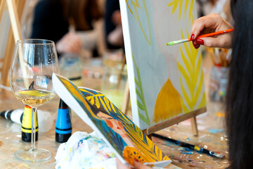 Women enjoying sip and paint event creating artwork