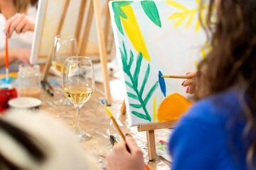 Women creating art during a sip and paint class