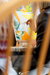 Woman painting with wine glass at art class