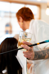 Woman holding paintbrush and wine glass at art workshop