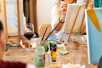 Women painting on canvas creating art during sip and paint event