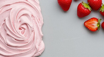 Pink whipped cream and fresh strawberries on gray surface