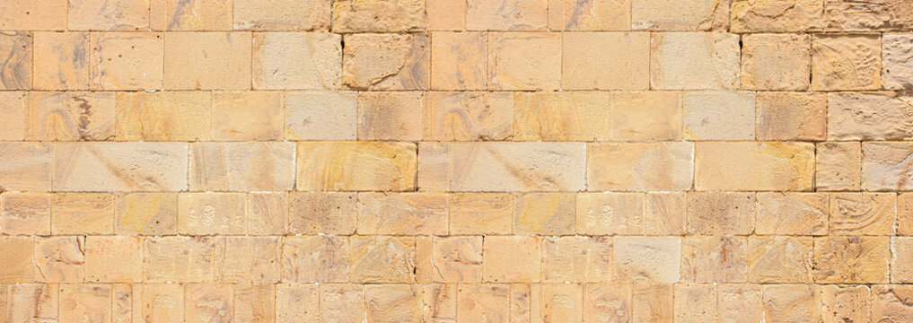 Textured ancient stone wall showing brick masonry pattern