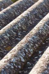 Old aged and damaged dangerous roof made of prefabricated and wave-shaped panels