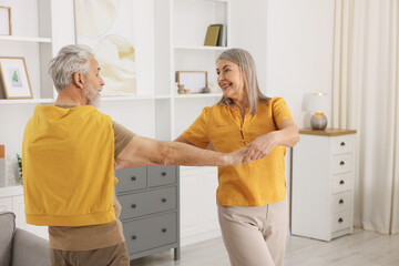 Fototapeta premium Lovely senior couple dancing together at home