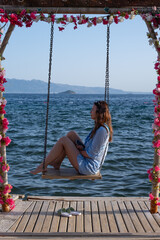 Enjoying a relaxing moment on a swing by the sea at a resort during a sunny day