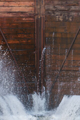 The old wooden gateway gate. The leaky lock gate on the canal. The leaking water is pressurized through holes and crevices.